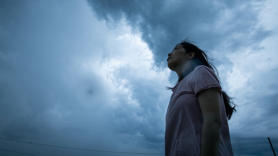 Žena gleda u olujno nebo