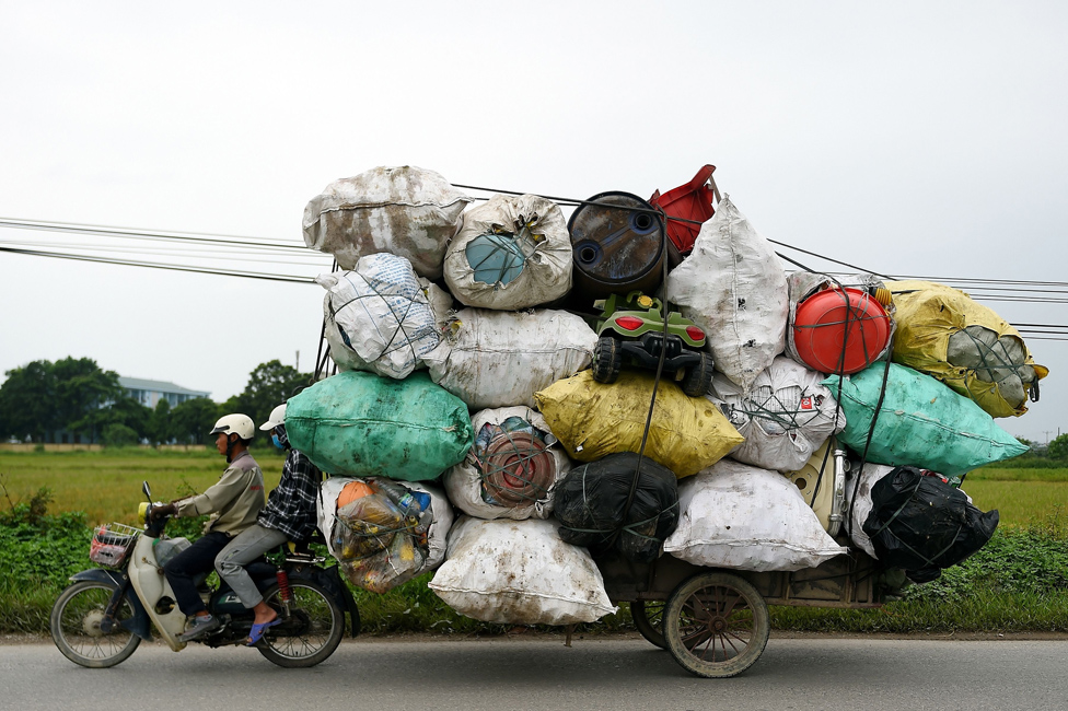 Waste collectors transport plastic scrap for recycling in the suburbs of Hanoi