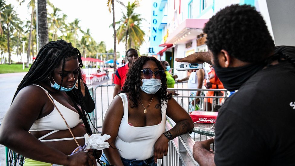 美國婦女在佛羅里達州邁阿密海灘一家餐廳的入口檢查體溫。