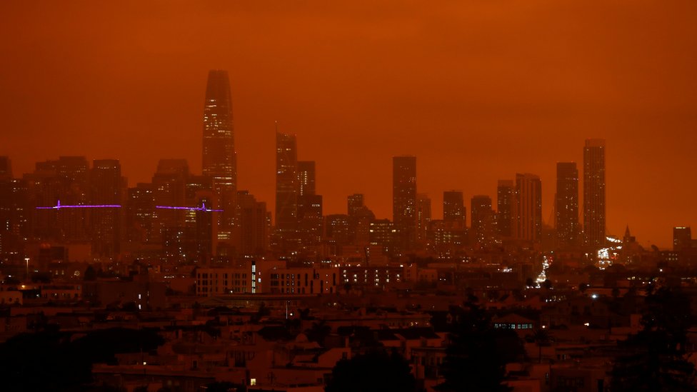 Prédios da cidade de São Francisco banhados por uma luz vermelha e fosca