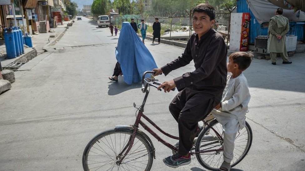Un hombre con un niño en una bicicleta.