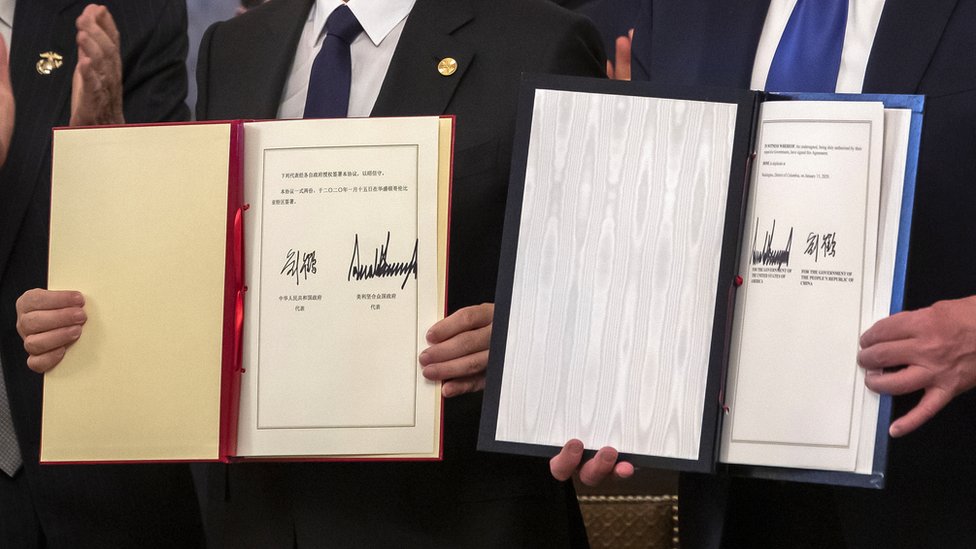 Вице-премьер Китая Лю Хэ (слева) и президент США Дональд Трамп (справа) подписывают частичное торговое соглашение