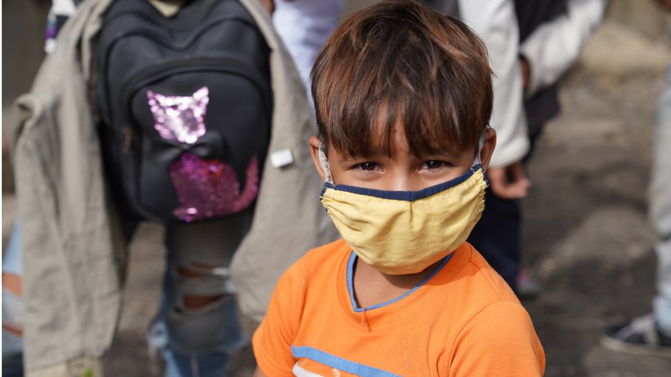 Ребенок, путешествующий с родителями, носит маску на въезде в Памплону, Колумбия