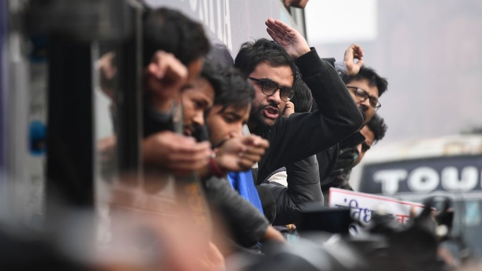 Протестующие реагируют из автобуса после ареста на демонстрации против нового закона о гражданстве Индии в Нью-Дели 19 декабря 2019 года.
