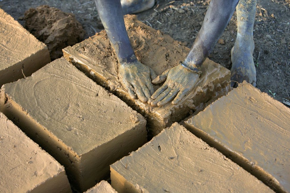 Эваристе Читегетсе формирует глиняные кирпичи, которые она будет использовать, чтобы построить дом своей семьи в Руйиги, Бурунди