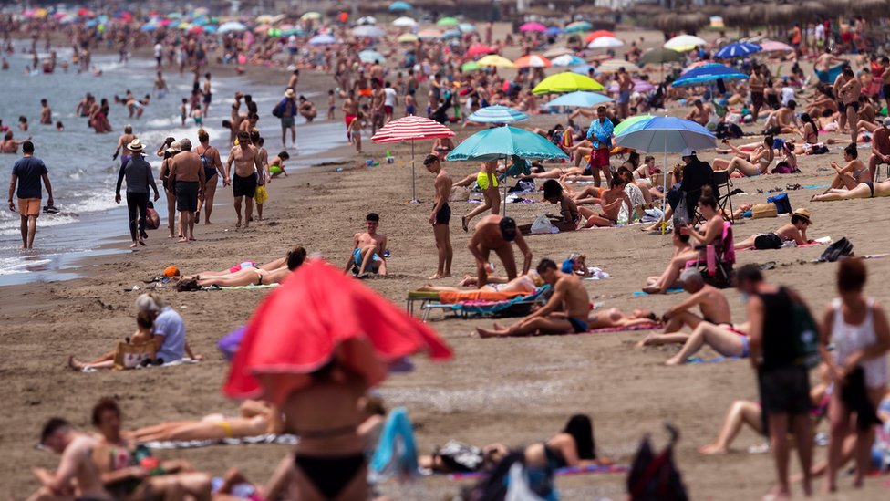 Люди в солнечный день на пляже в Малаге в июне