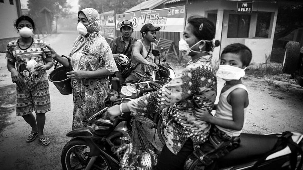 Местные жители Беренг-Бенгкеля ведут повседневную жизнь в масках-дымках