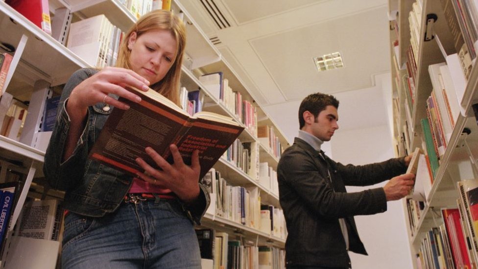 momak i devojka čitaju u biblioteci