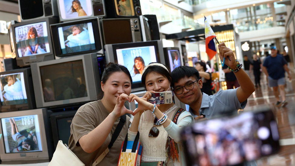 新加坡濱海灣金沙購物中心的泰勒·斯威夫特裝置作品前，粉絲們舉著菲律賓國旗拍照留念