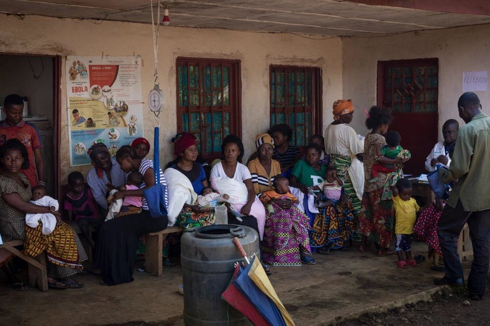 Родители с детьми выстраиваются в очередь перед поликлиникой Иганда