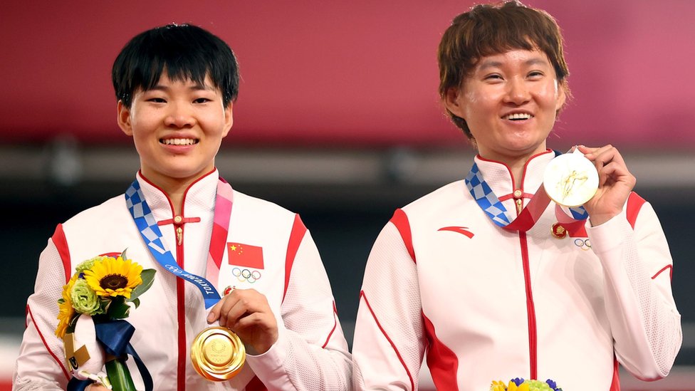 鍾天使（右）、鮑珊菊（左）站在頒獎台上展示其奧運金牌（2/8/2021）