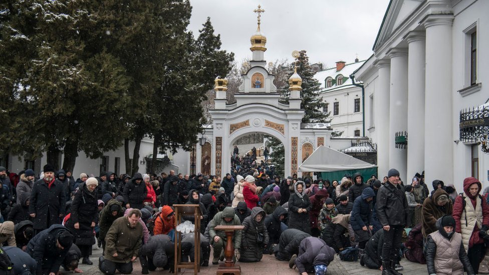 يصلي الناس خارج كنيسة في مجمع دير كييف بيشيرسك لافرا في 29 مارس/آذار