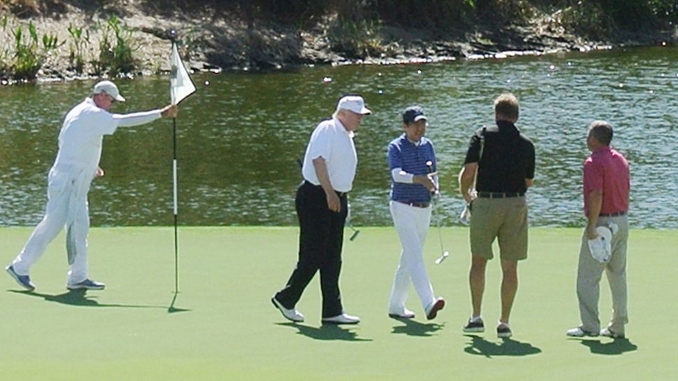 Президент США Дональд Трамп и премьер-министр Японии Синдзо Абэ играют в гольф во Флориде 11 февраля 2017 г.