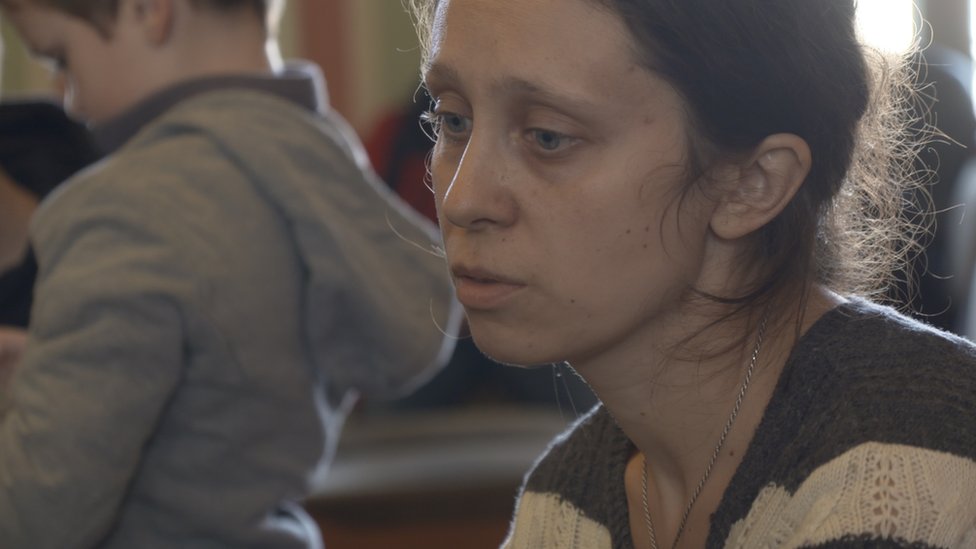 Una mujer en la sala de espera de la estación de tren.