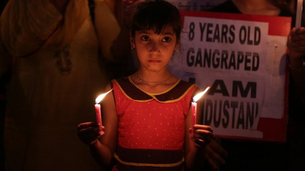 Индийская девочка держит свечи, когда она вместе со своими родственниками принимает участие в марше при свечах в знак протеста против изнасилования и убийства восьмилетней девочки в Катуа, Амритсар, Индия, 15 апреля 2018 г.