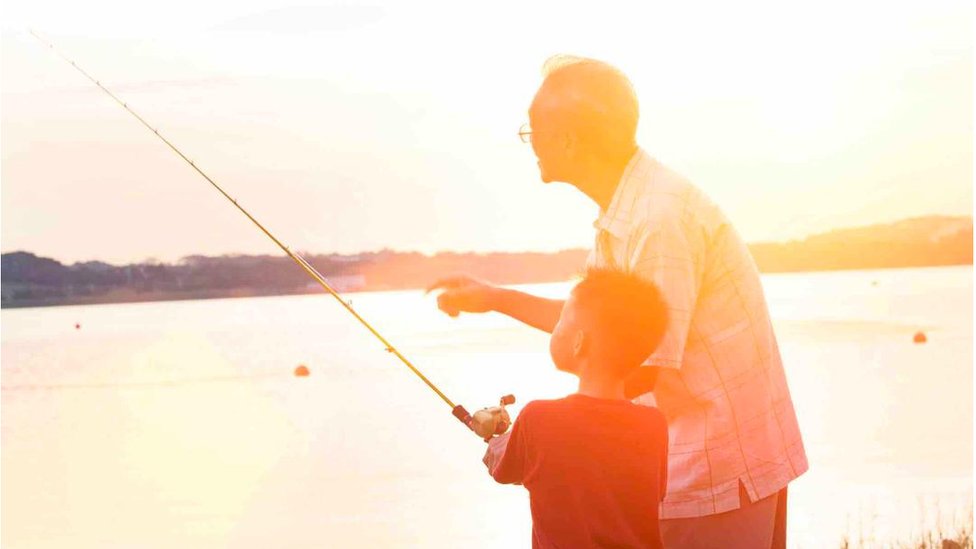 男孩和他的祖父在一起釣魚。