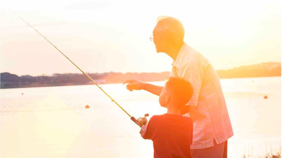 A boy and his grandfather fishing