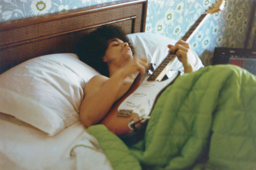 Принц играет на гитаре в постели в своем новом доме на Франс-авеню, апрель 1978 г.