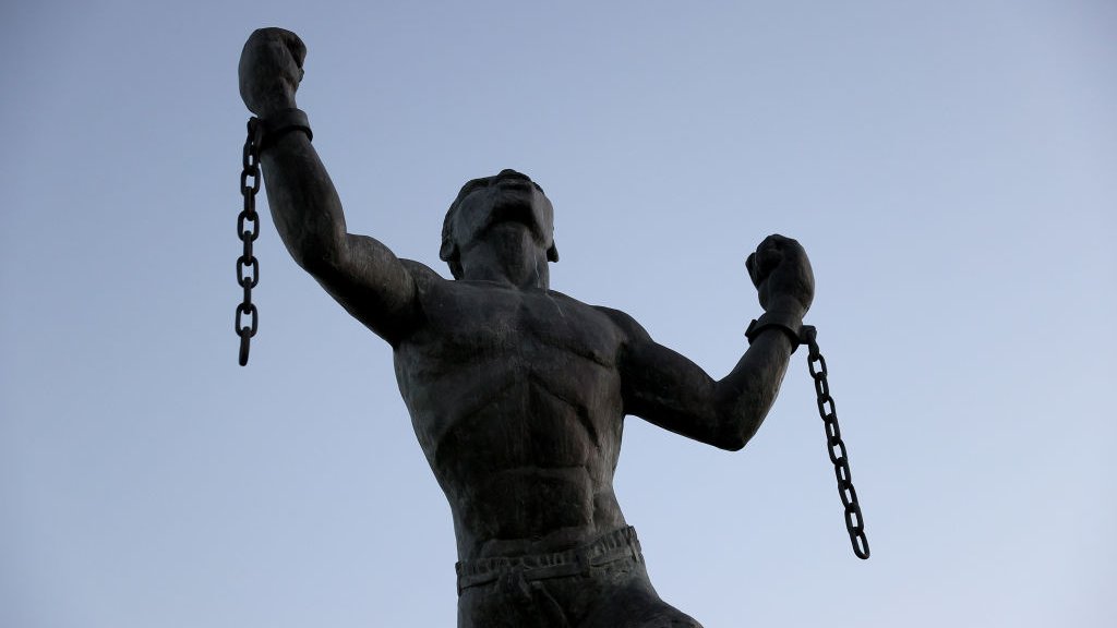 Escultura de esclavo rompiendo cadenas