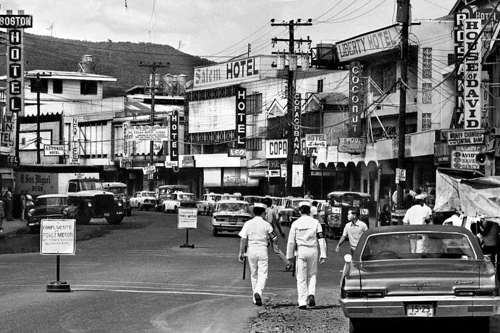 Foto en blanco y negro que muestra a unos marinos caminando por la localidad filipina de Olongapo en los años 70.
