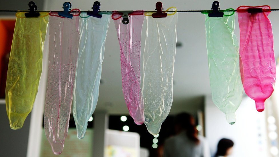 Los profesionales sanitarios recomiendan el uso de condón como el método más barato y fiable de prevención contra el sida. Condones en diferentes colores colgados en un tendedero en China
