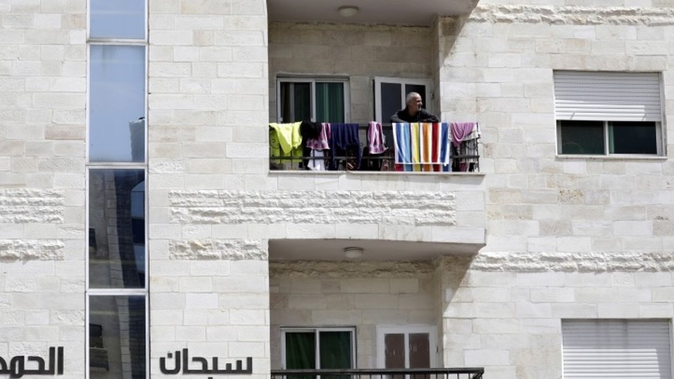 Мужчина смотрит со своего балкона в Аммане, Иордания