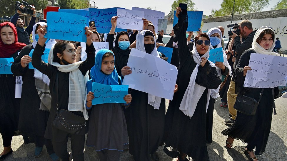 Mulheres e meninas afegãs participam de um protesto em frente ao Ministério da Educação em Cabul em 26 de março de 2022, exigindo que as escolas secundárias sejam reabertas para meninas.