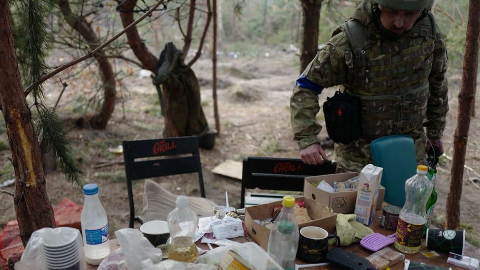 Ukrainian soldier examines stuff left behind by Russian troops