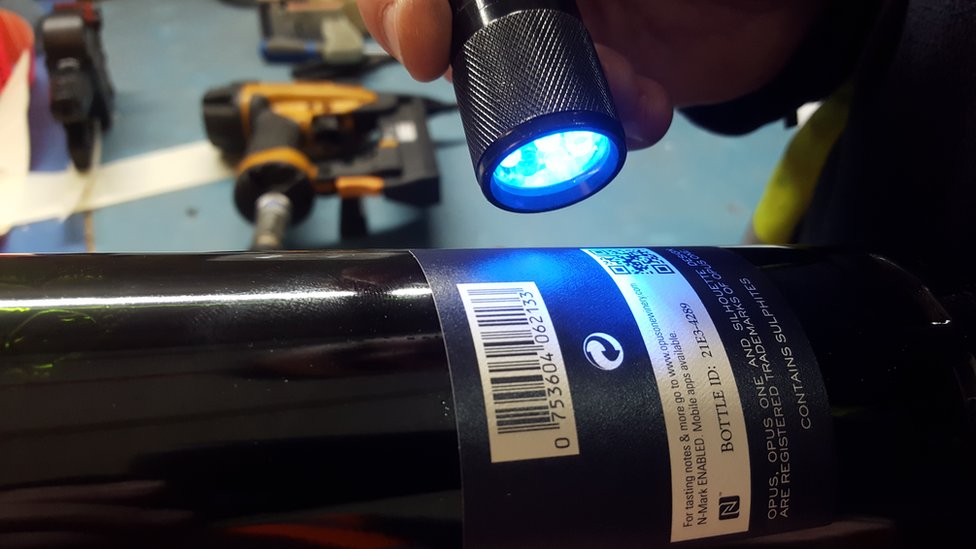 Moulin usa luz ultravioleta para examinar las botellas. Botella de vino