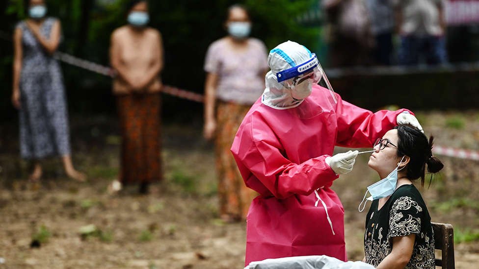 A medical worker take a swab sample of a woman to test for COVID-19 coronavirus at a quarantine facility in Yangon - 16 October 2020