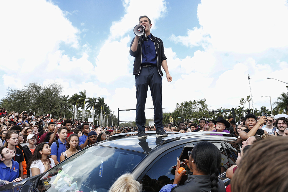 Cameron Kasky dando un discurso ante una multitud sobre un carro