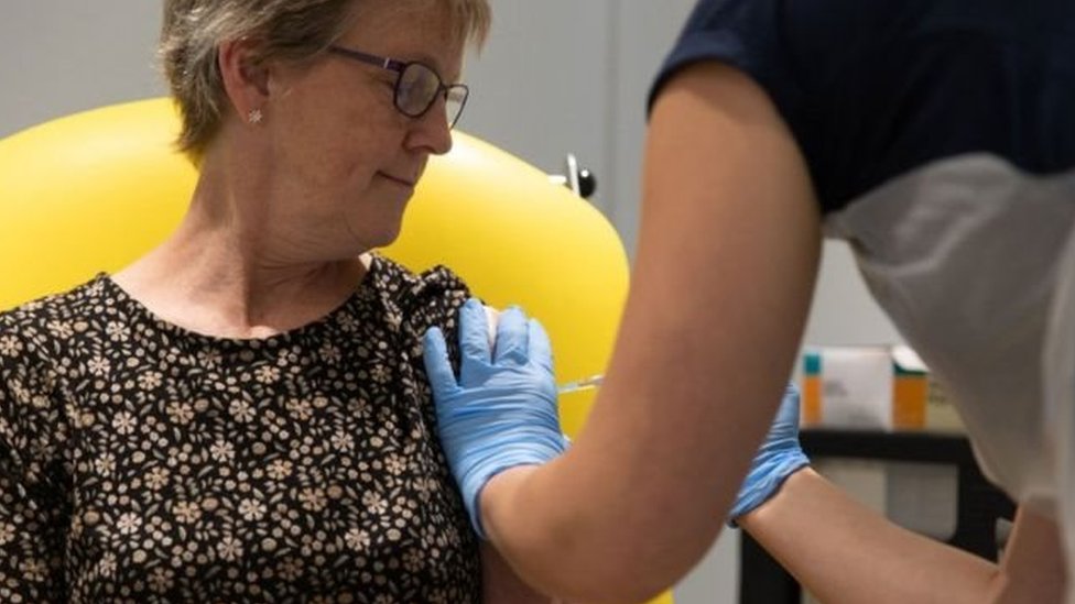 Mulher recebe injeção de vacina