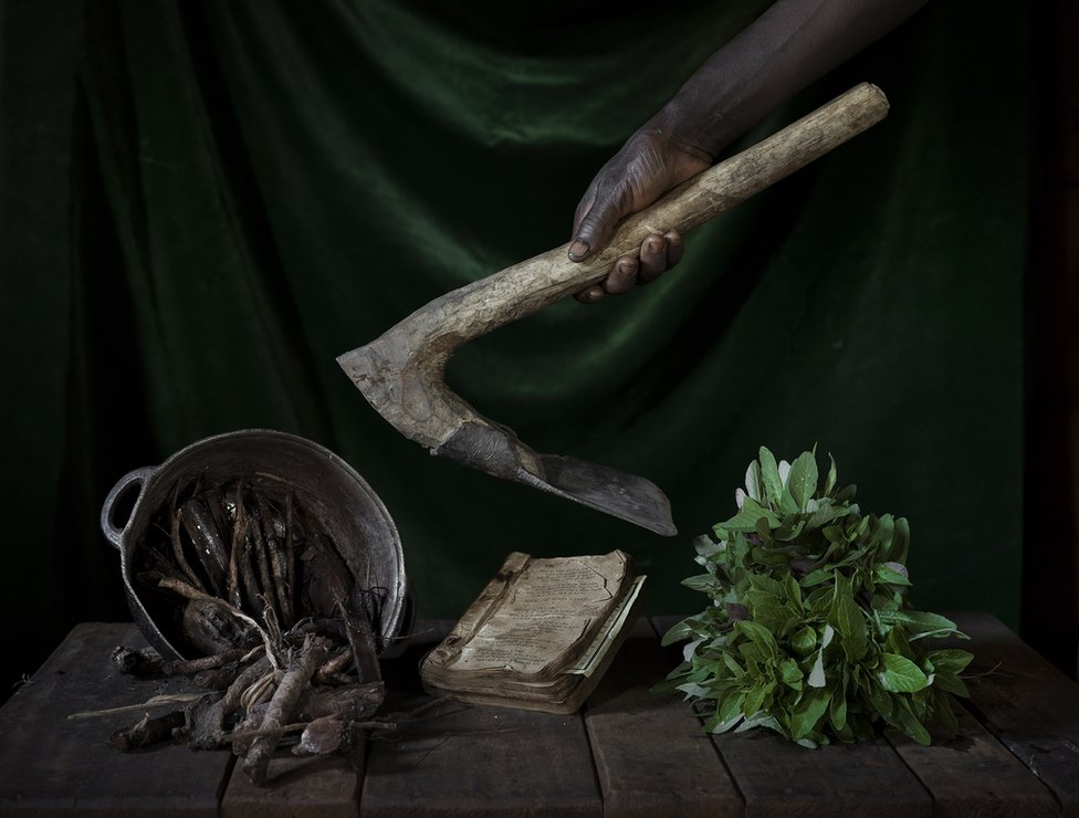 Предметы на деревянном столе и рука, держащая сельскохозяйственный инструмент