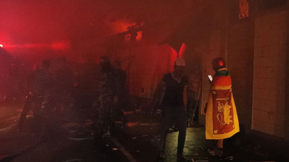 Protesters outside the burning prime minister's residence