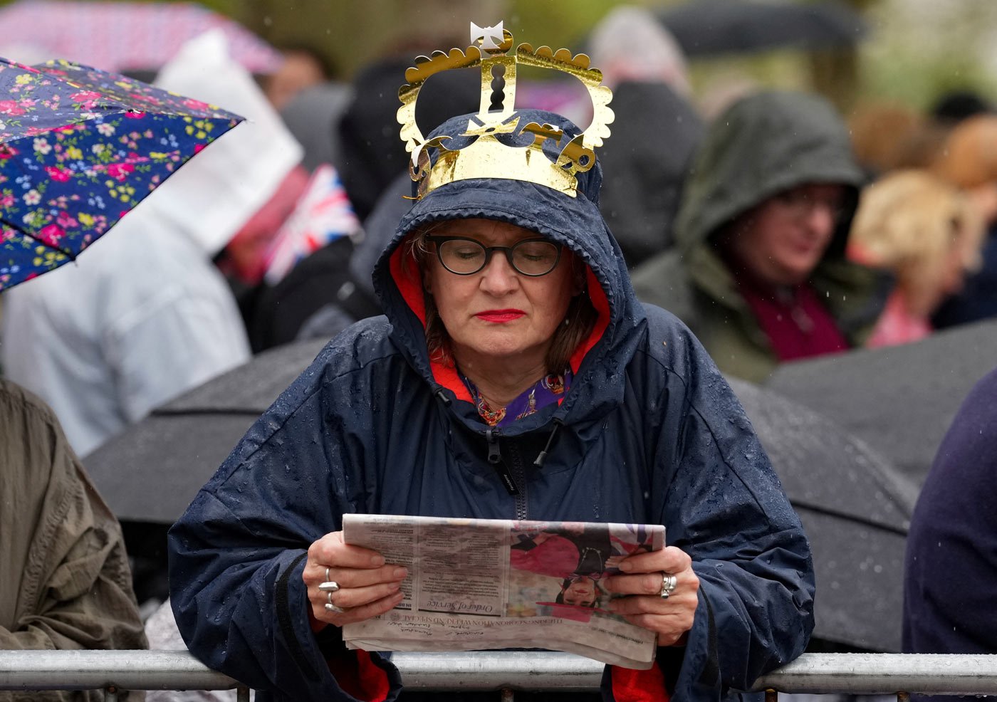 A royal fan waits for the procession to begin on The Mall in London