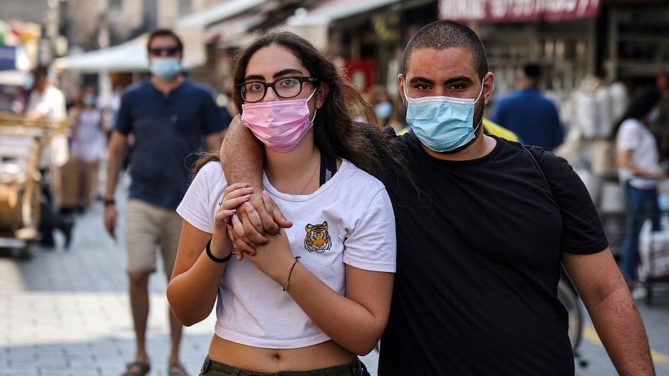 A masked couple takes a walk at the Mahane Yehuda market in Jerusalem on 17 September, a day ahead of Rosh Hashana