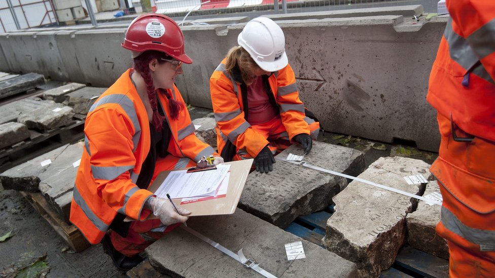 Волонтеры в Лондоне записывают надгробие перед тем, как оно будет снято перед началом строительства HS2.
