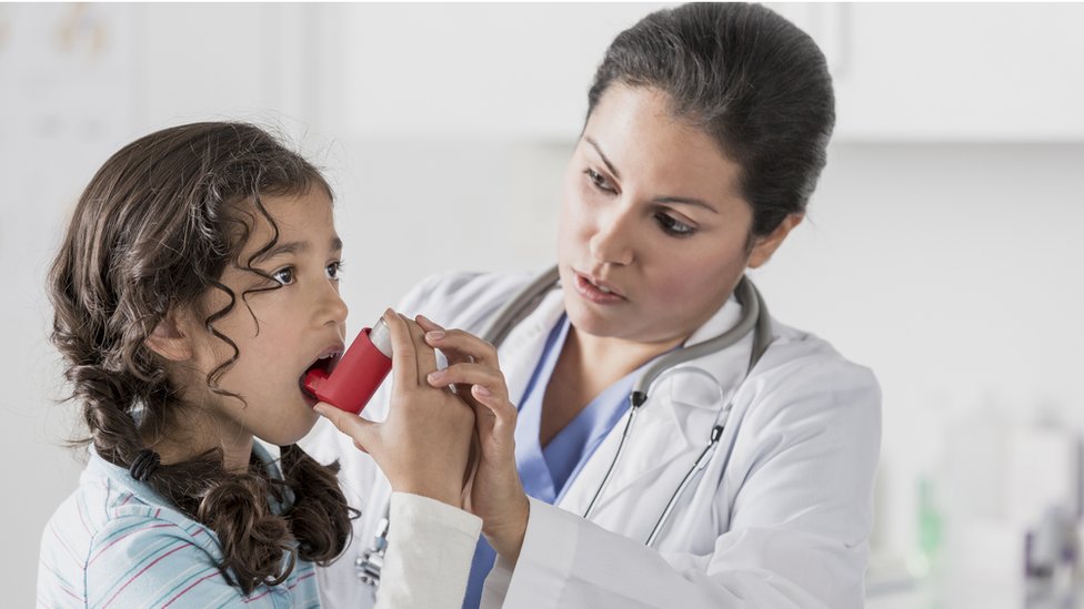 Little girl learning to use an inhaler.
