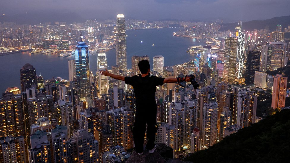 香港太平山上一位遊客邊俯瞰夜景邊張開雙臂（9/5/2023）