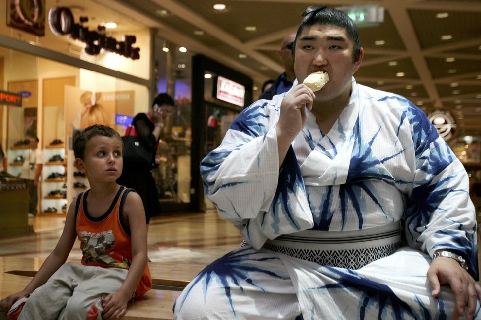 Los luchadores de sumo también deben vestir ropas exclusivas dentro y fuera de las competencias. (Foto: Uriel Sinai/Getty Images) Luchador de sumo tomando un helado con su vestimenta tradicional. ((Foto: Uriel Sinai/Getty Images)