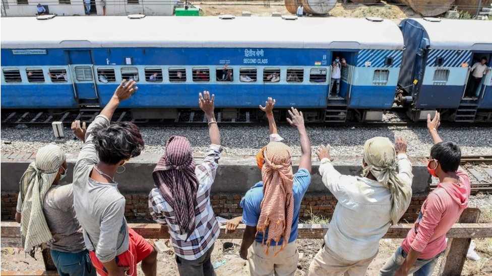 Radnici stoje pored voznog puta i mašu migrantima koji posebnim vozom odlaze iz Amritsara do Baraunija