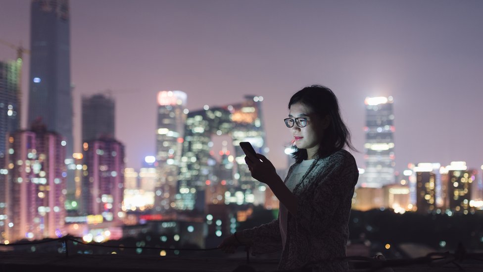 Китайская женщина пользуется телефоном