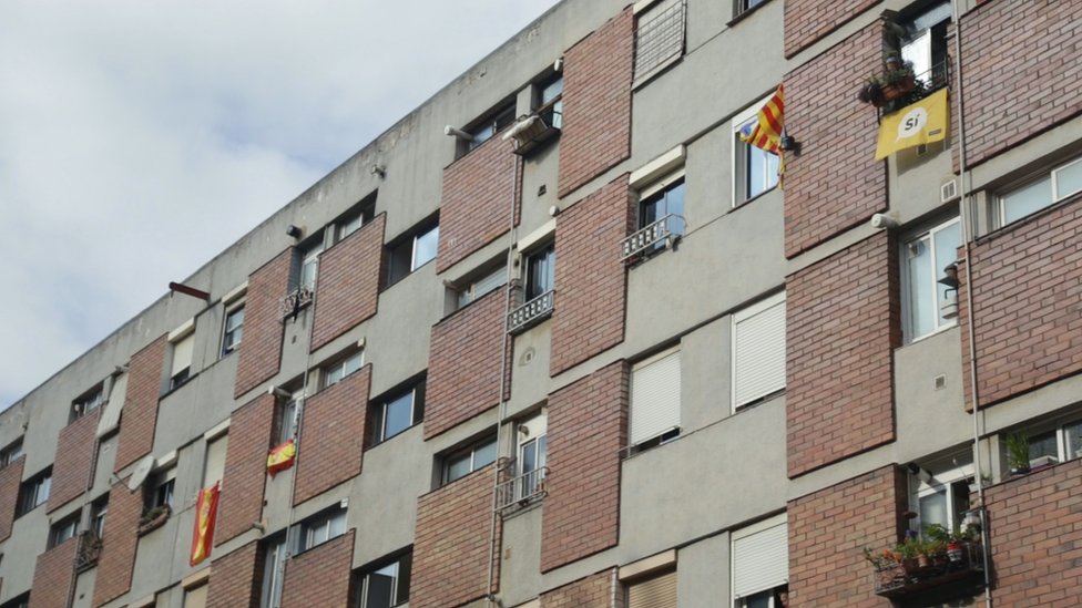 La independencia de Cataluña parece ocupar los últimos lugares en la lista de preocupaciones de los que viven aquí. Banderas de España y de Cataluña cuelgan de ventanas en un conjunto residencial de Ciutat Meridiana.