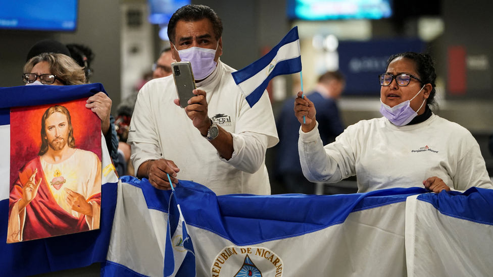 Miembros de la diáspora de Nicaragua con banderas en el aeropuerto de Washington