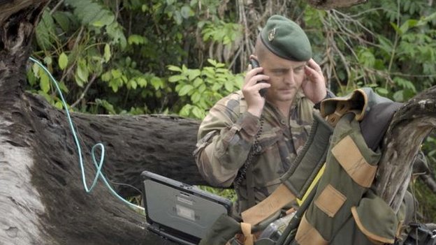 Capitão Vianney, fardado, fala no celular no meio da floresta