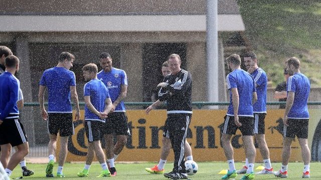 Northern Ireland players dodge a sprinkler during training in France