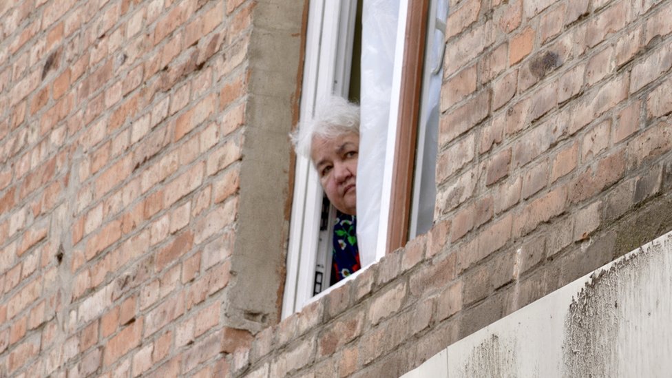 Lyudmila appears at the window of her apartment