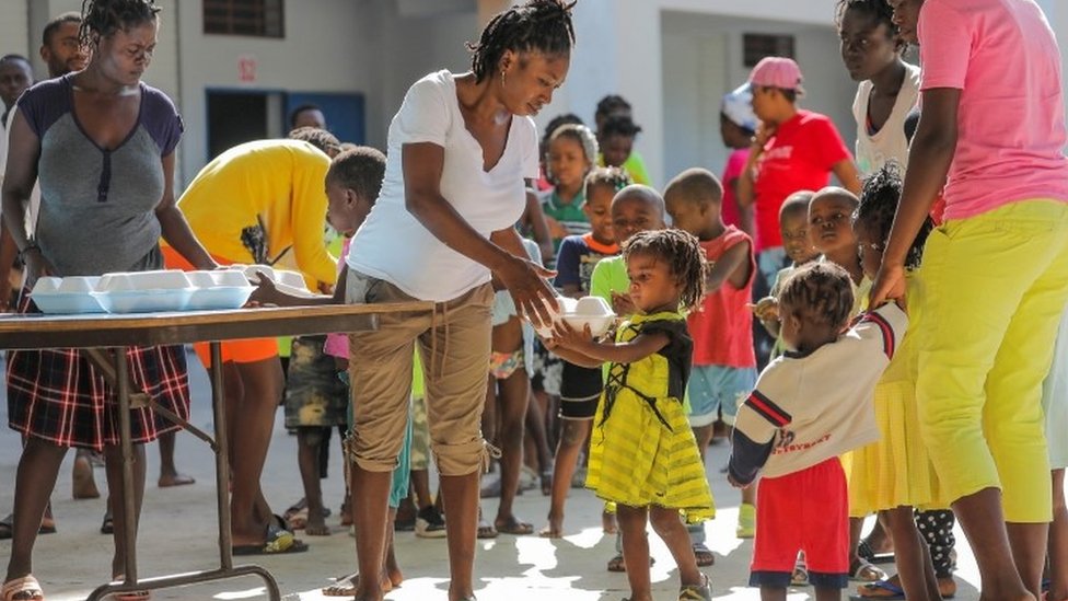 Niños que escaparon de la violencia en Cité Soleil hacen fila para recibir comida mientras se refugian en una escuela en Puerto Príncipe.