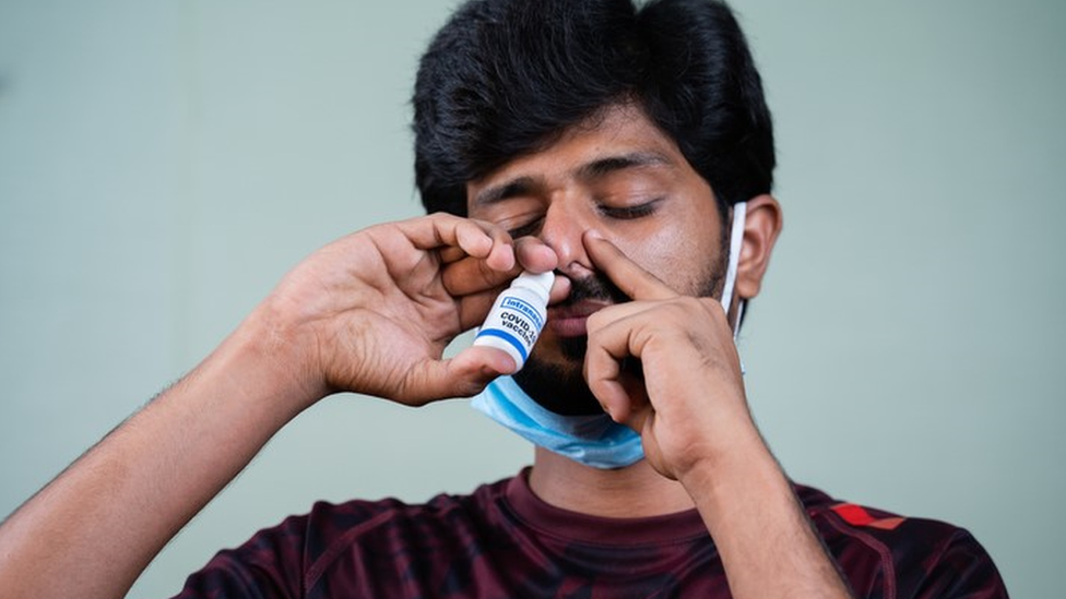 Homem aplica vacina no nariz