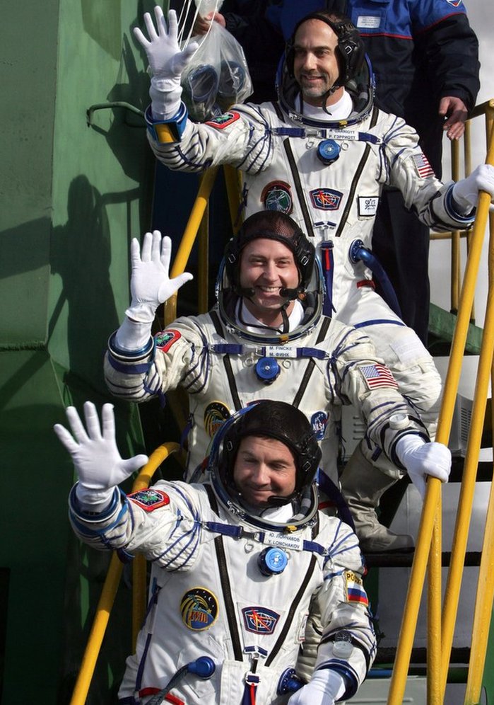 Russian cosmonaut Yury Lonchakov (bottom), US astronaut Michael Fincke (centre) and his compatriot, space tourist Richard Garriott (top), wave as they board the spacecraft at the Baikonur cosmodrome, in Kazakhstan, on 12 October, 2008.